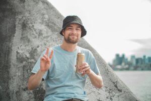 man in teal crew neck t-shirt holding ice cream cone