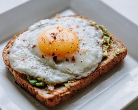 bread with sunny side-up egg served on white ceramic plate