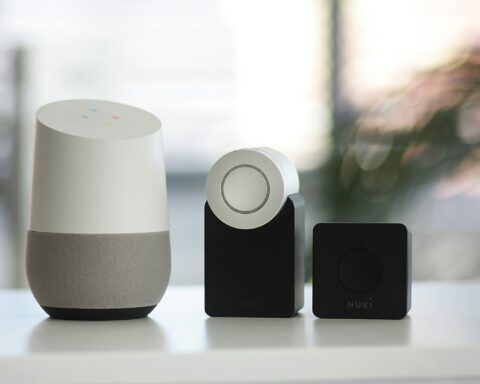 white and gray Google smart speaker and two black speakers