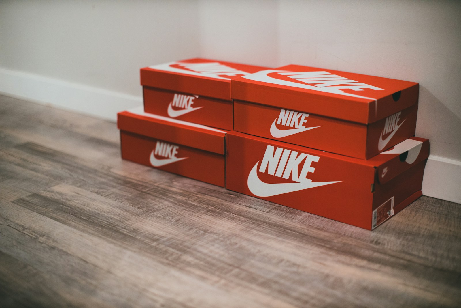 a pair of red nike boxes sitting on top of a wooden floor