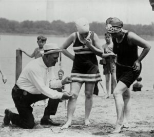 Col. Sherrell, Supt. of Public Buildings and Grounds measuring swimsuits