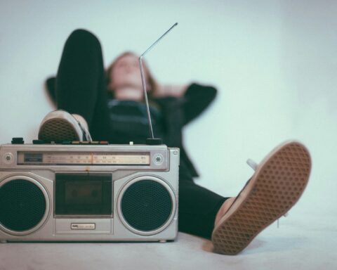 woman laying on bed near gray radio